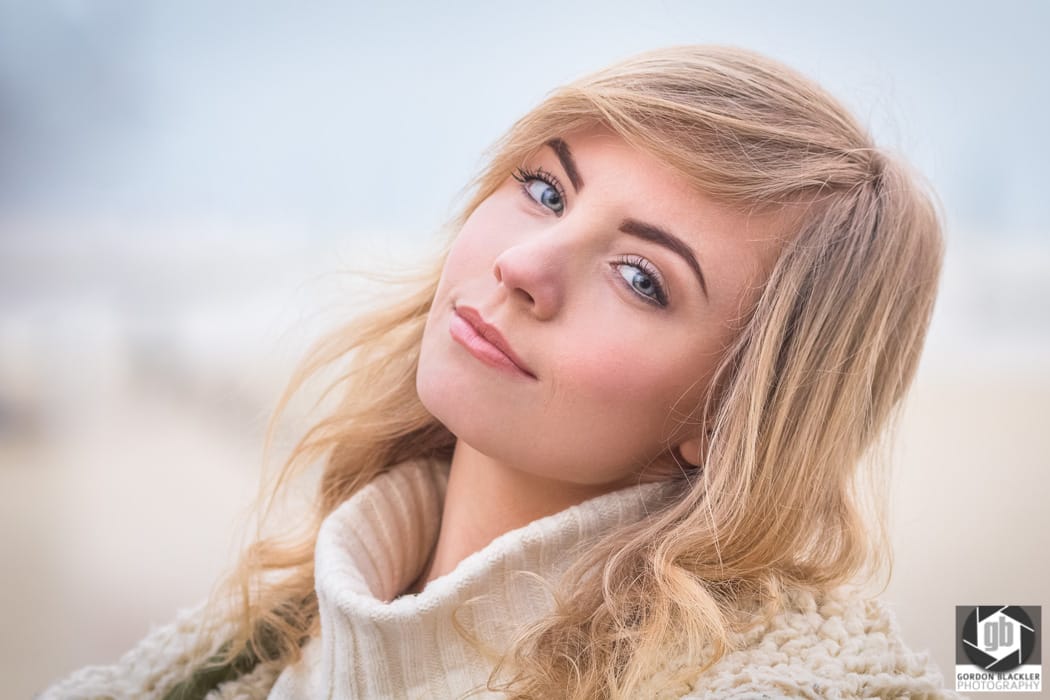 beautiful young blonde woman wearing a chunky white sweater